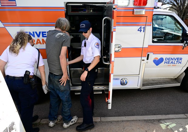 Denver Health paramedic field trainer Keri Reiner, left, and paramedic Aiden Beatty, right, help a dog bite victim in north Denver on April 3, 2024. (Photo by Andy Cross/The Denver Post)